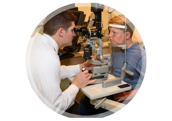 Dr. Tyler Mazur conducting an eye exam on a boy.